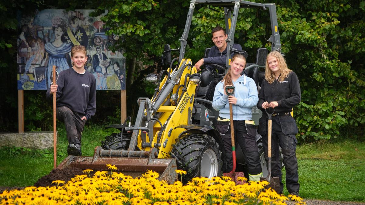 Hjullaster og fire elever i parken, med redskaper