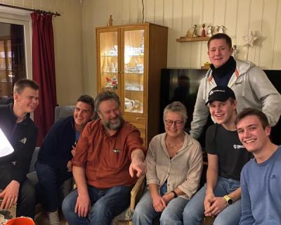 Ungdommer samlet i en stue sammen med to voksne.