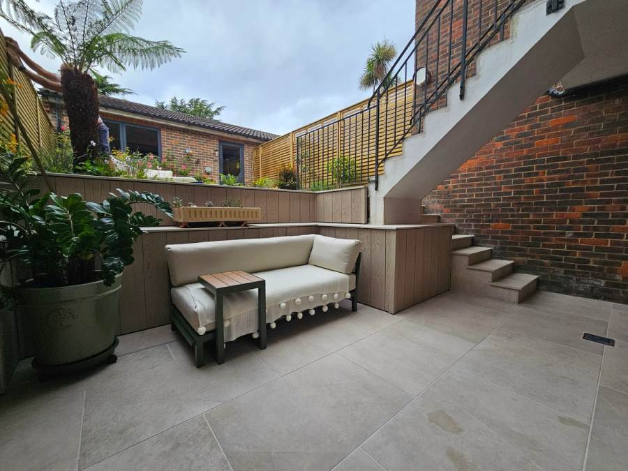 Finished courtyard with paving, planting and built-in seating by Landscape Artisan