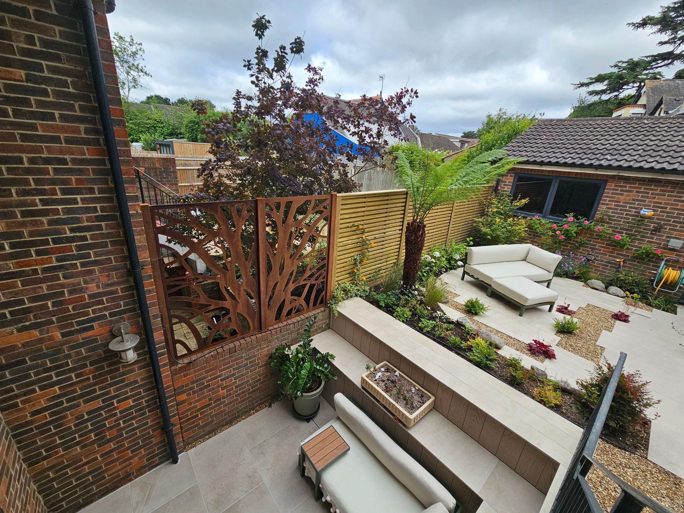 Garden seating area framed by planting and timber structures
