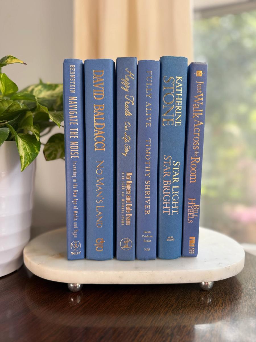 Curated collection of deep navy, warm ivory, brown, and gold-accented books with classic traditional character.