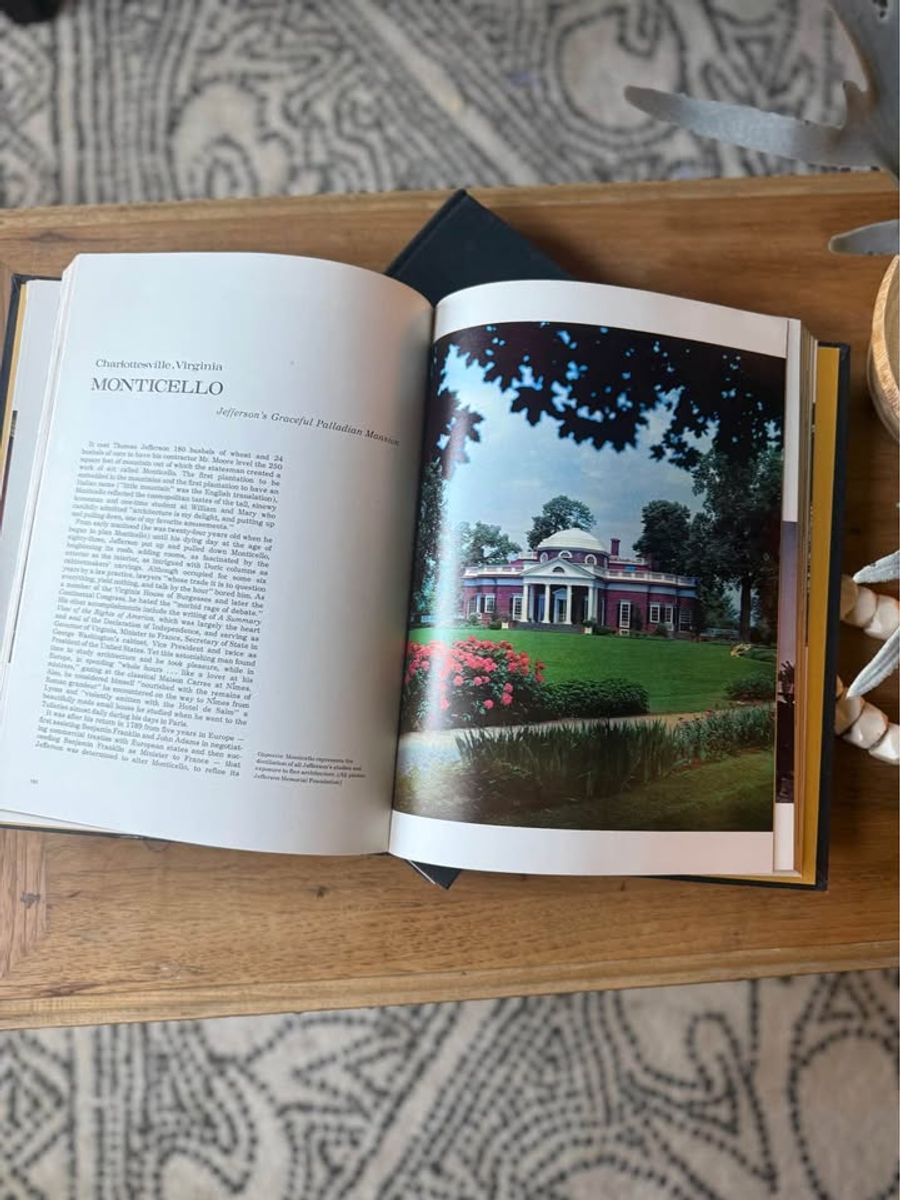 Curated pair of oversized black hardcover books with deep charcoal-black covers, warm aged page edges, and understated gold and cream lettering.