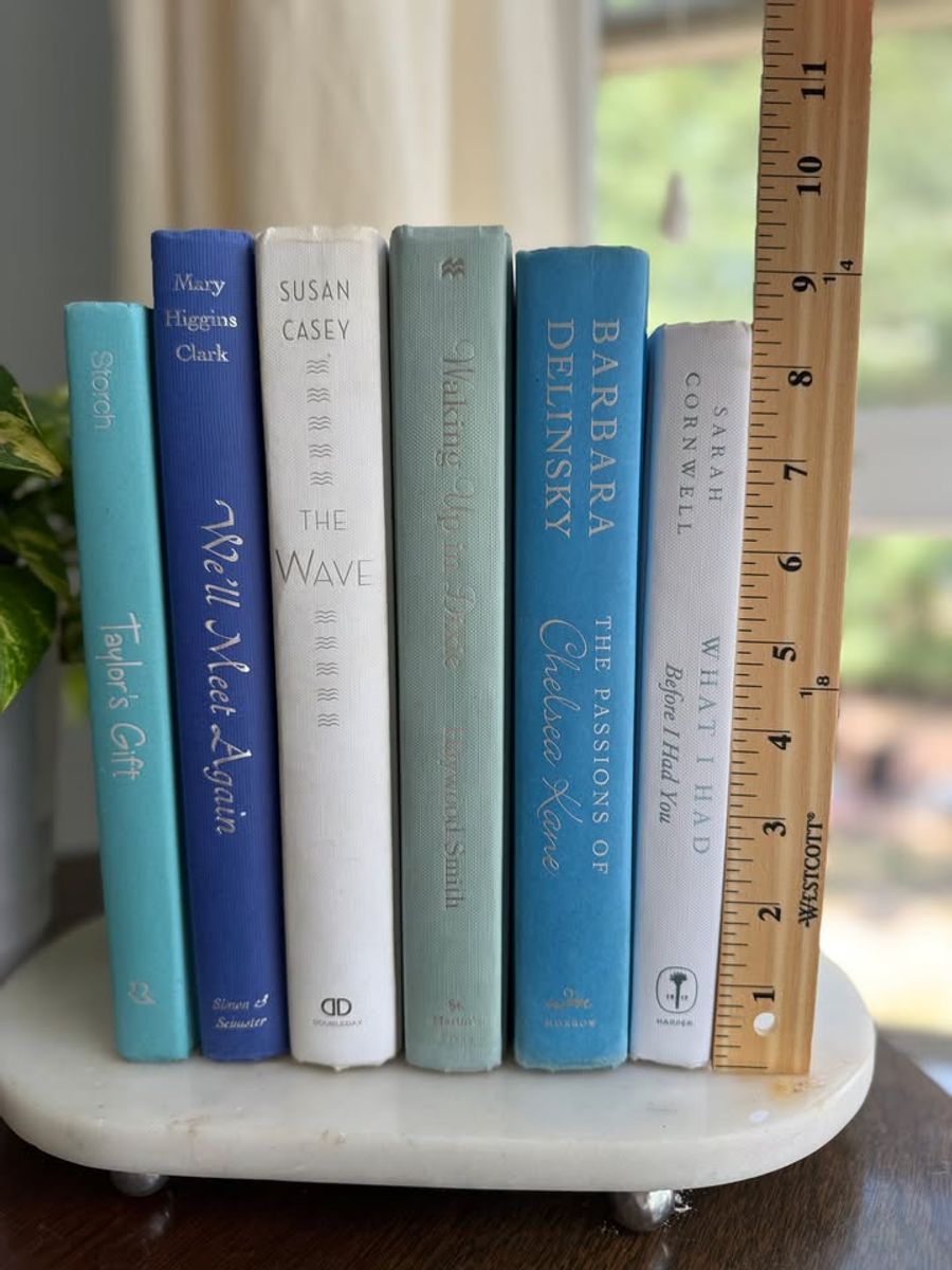 Sea Glass No. 33 decorative book collection in turquoise, cobalt blue, white, pale aqua, and soft gray tones, tied with neutral linen ribbon and styled on a marble table.