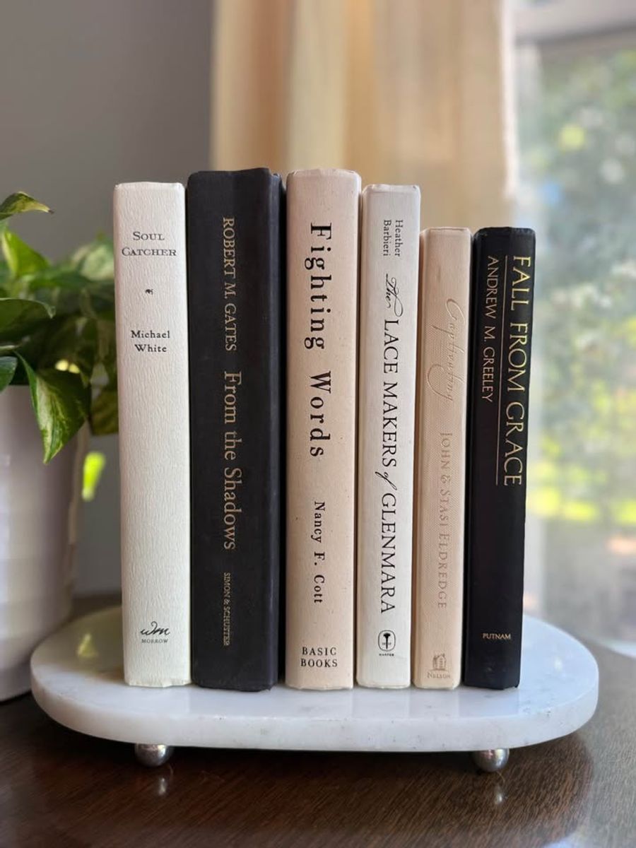 Curated collection of parchment, cream, warm beige, and black books with soft neutral contrast and classic detailing.