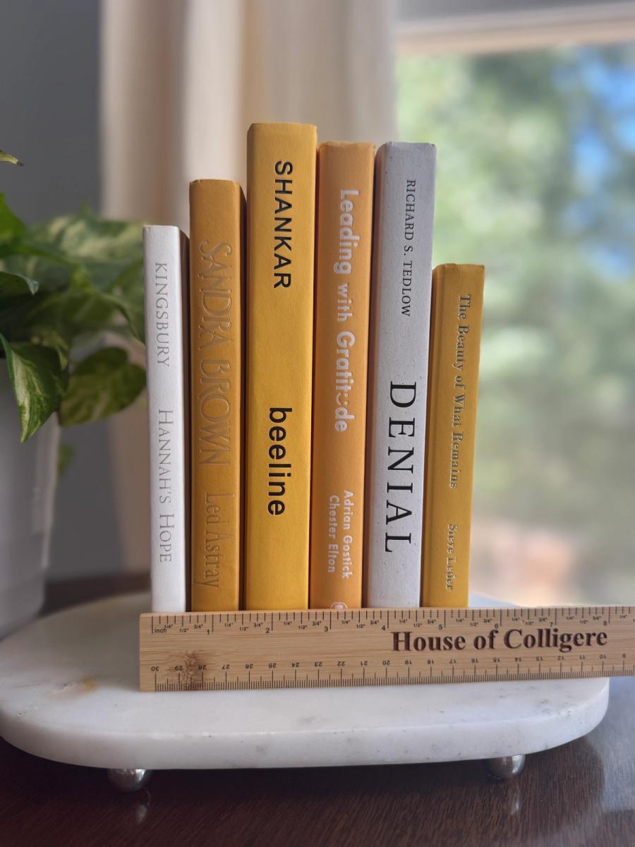 Six curated hardcover books in mustard yellow, golden ochre, cream, and soft white tones, tied with natural linen ribbon and displayed with a House of Colligere Modernist Edit No. 5 card.