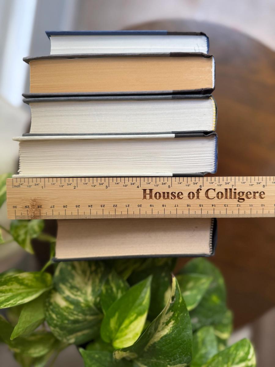 Curated collection of rich charcoal and black books with warm gold lettering and dramatic tonal depth.