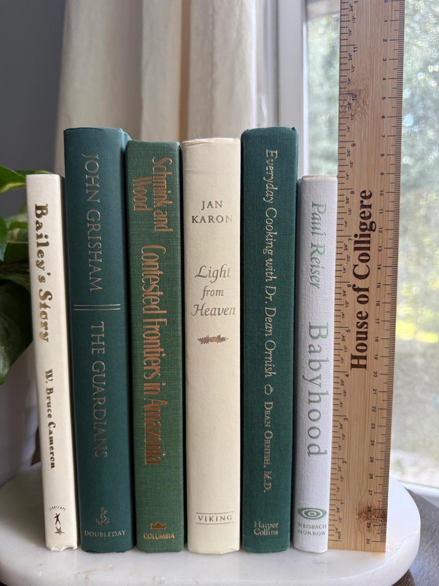 Curated collection of soft sage, olive, cream, and muted green books with botanical tones.