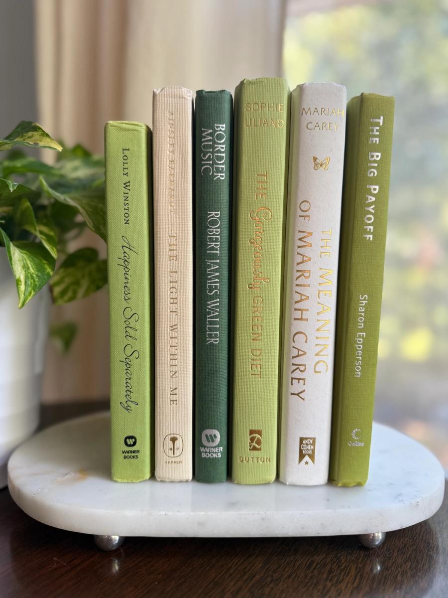 Curated collection of soft sage, olive, cream, and muted green books with botanical tones.