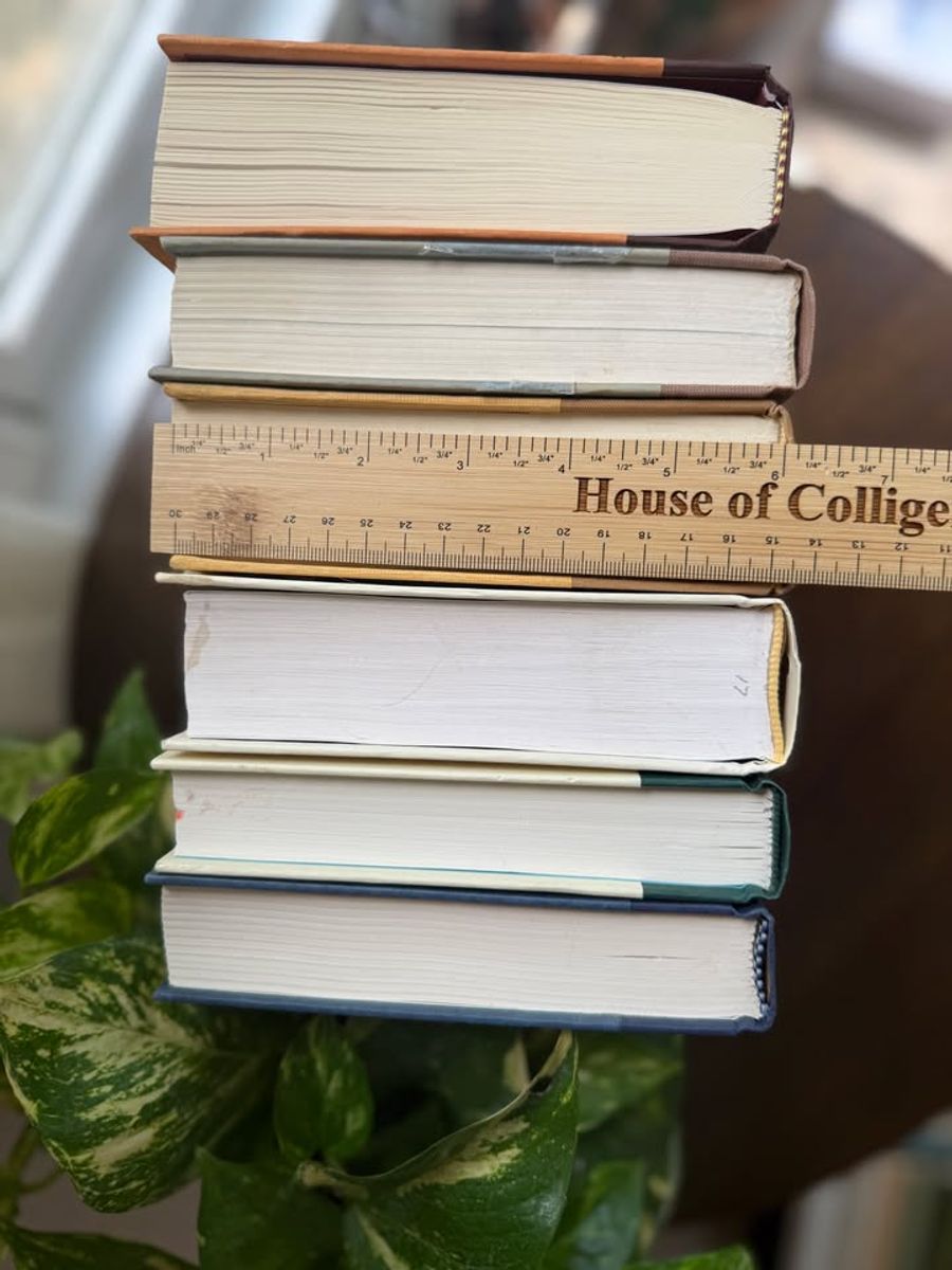 Curated collection of rich brown, hunter green, deep navy, and warm ivory books with classic gold accents.
