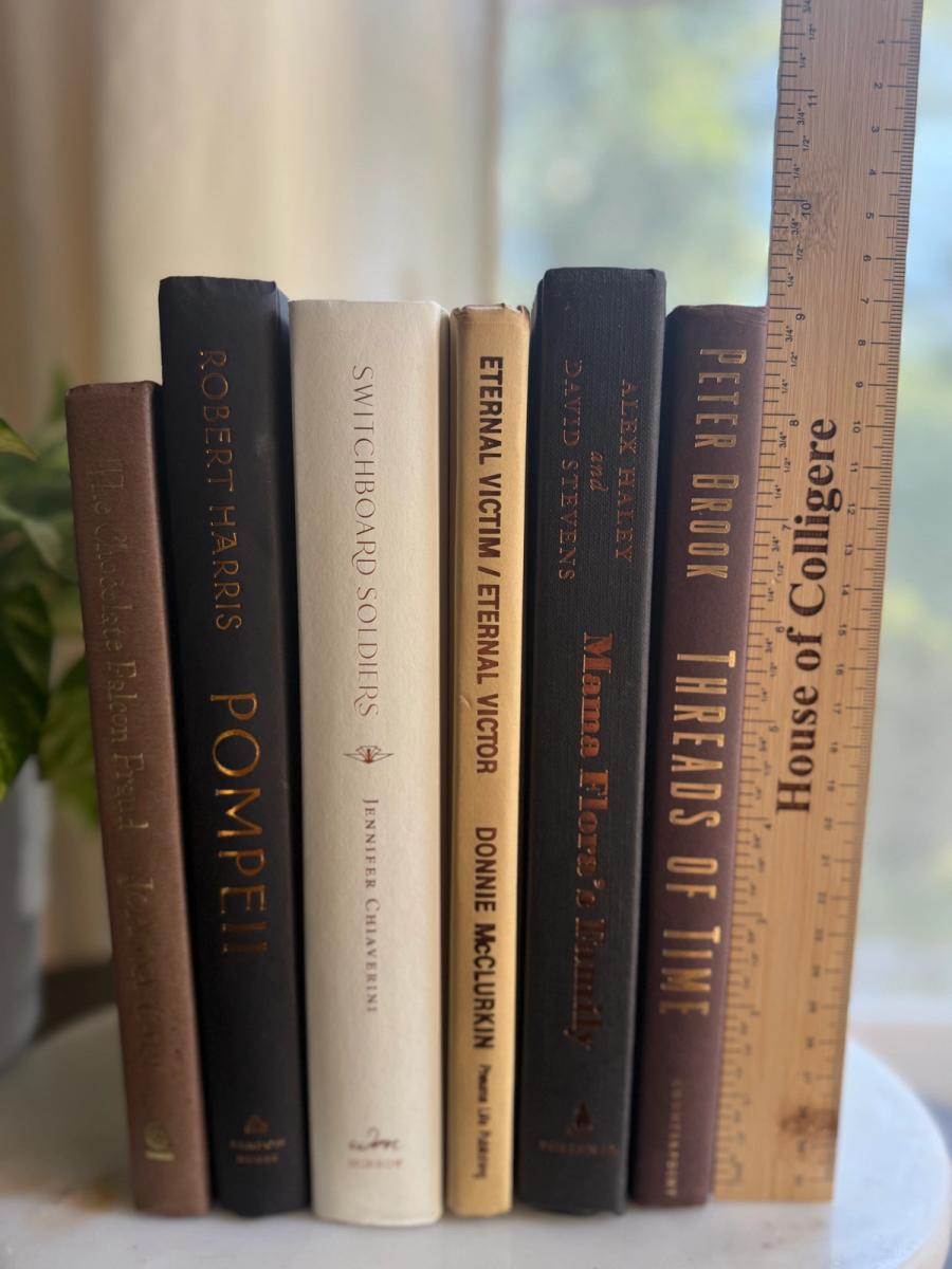 Curated collection of warm brown, olive, tan, and aged neutral books with a traditional library palette.