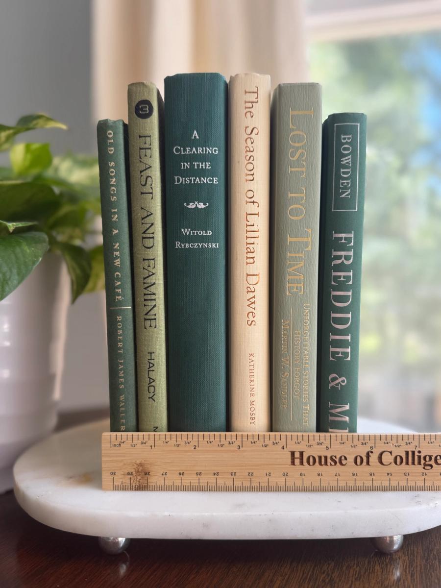 Curated collection of soft sage, olive, cream, and muted green books with botanical tones.