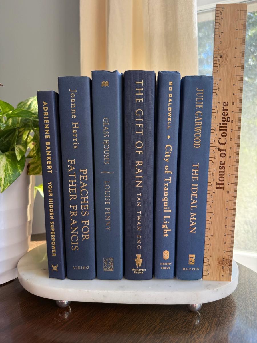 Curated collection of deep navy, warm ivory, brown, and gold-accented books with classic traditional character.