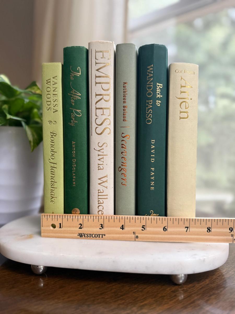 Curated collection of soft sage, olive, cream, and muted green books with botanical tones.