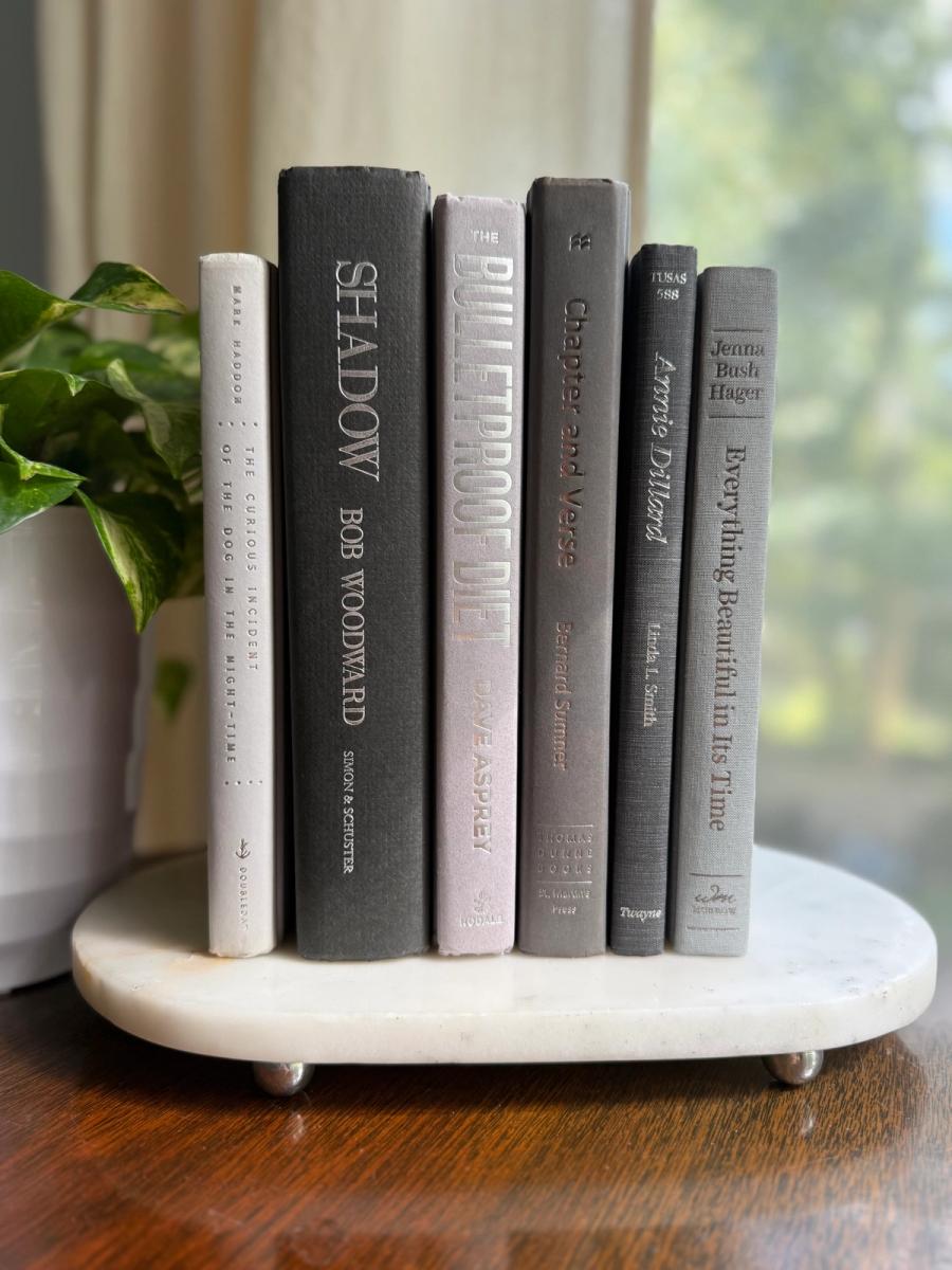 Curated collection of soft white, pale gray, warm greige, and stone-toned books with subtle tonal variation.