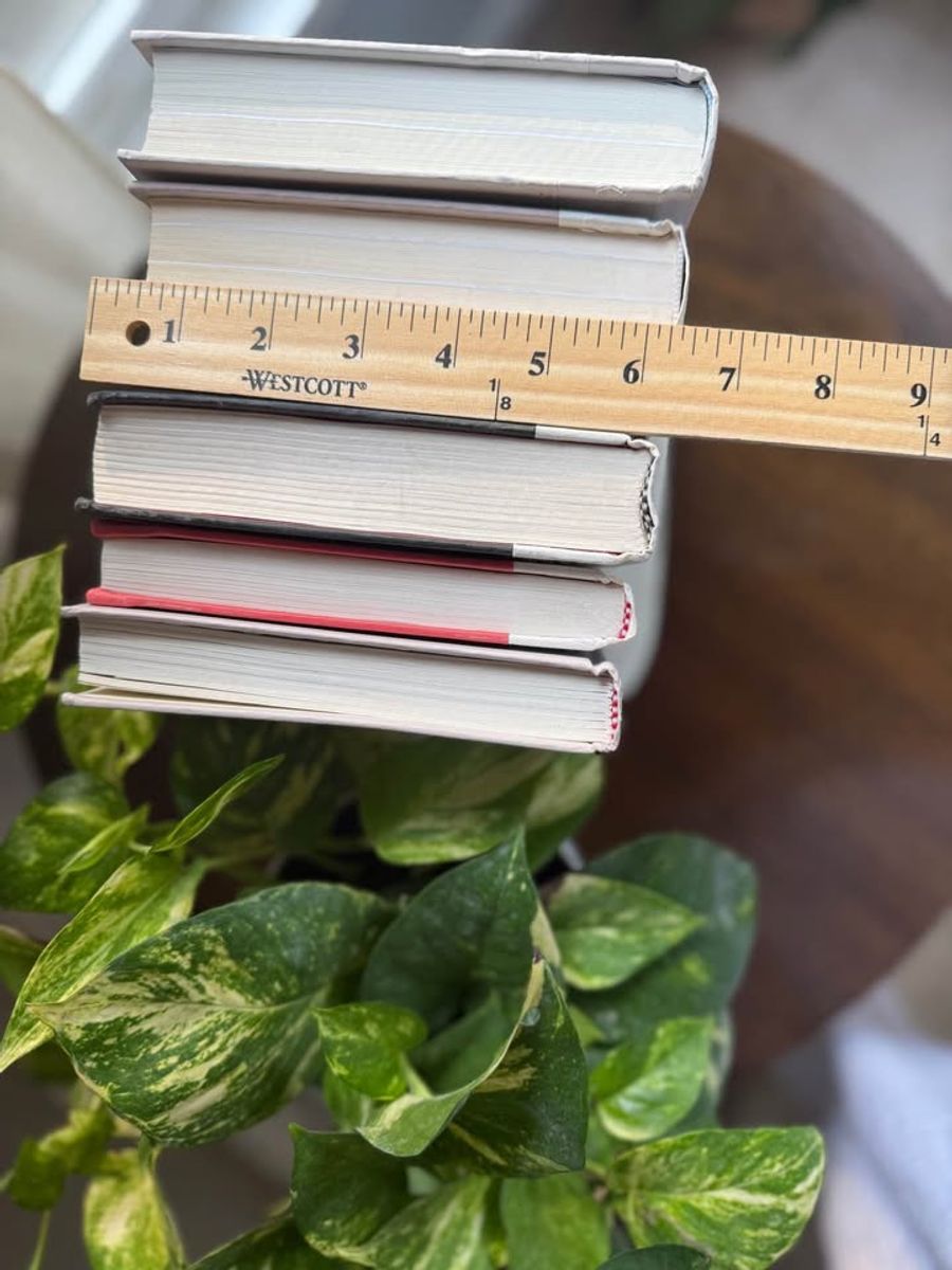Curated collection of soft white, pale gray, warm greige, and stone-toned books with subtle tonal variation.