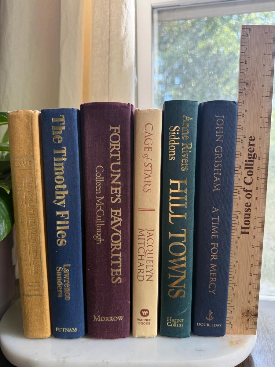 Curated collection of rich brown, hunter green, deep navy, and warm ivory books with classic gold accents.