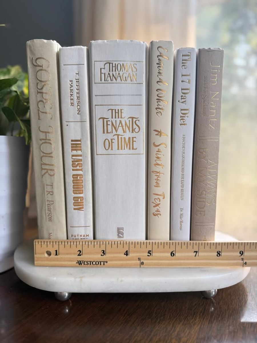 Curated collection of crisp white, ivory, and warm cream books with soft neutral tones.