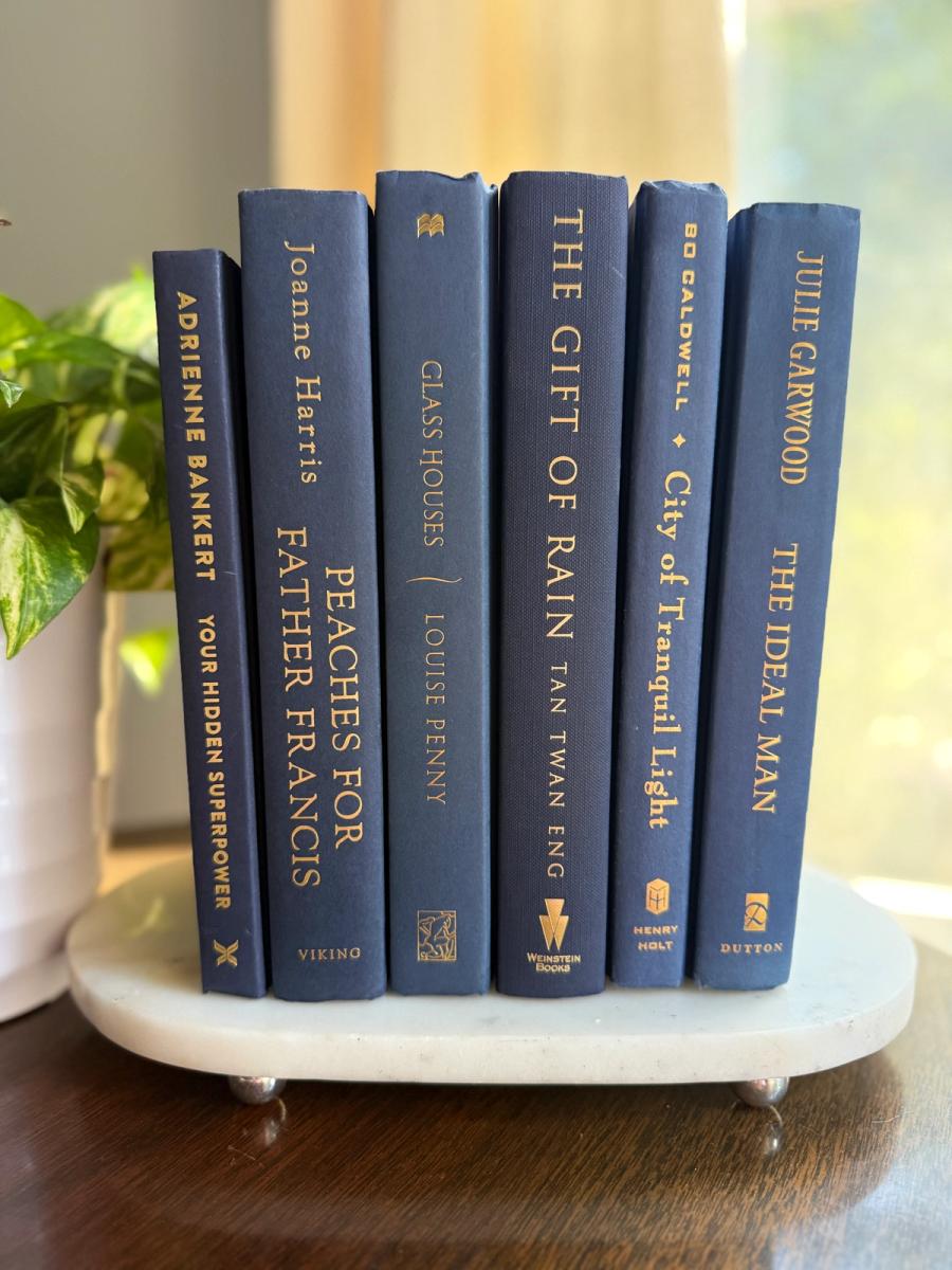 Curated collection of deep navy, warm ivory, brown, and gold-accented books with classic traditional character.