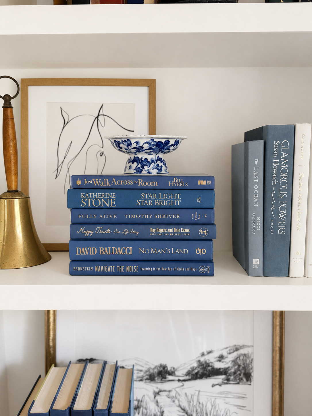 Curated collection of deep navy, warm ivory, brown, and gold-accented books with classic traditional character.