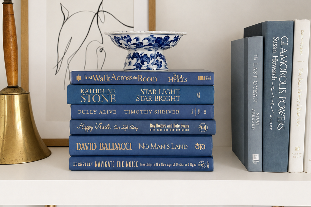 Curated collection of deep navy, warm ivory, brown, and gold-accented books with classic traditional character.