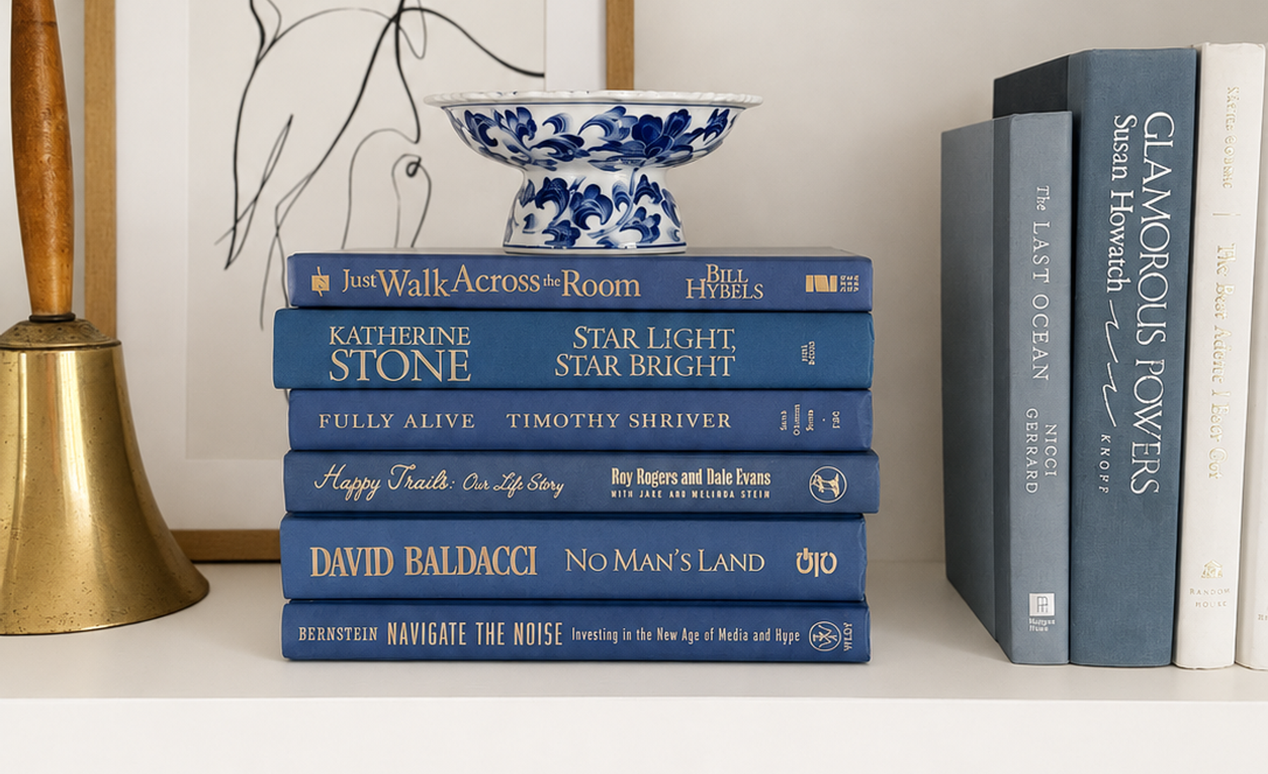 Curated collection of deep navy, warm ivory, brown, and gold-accented books with classic traditional character.