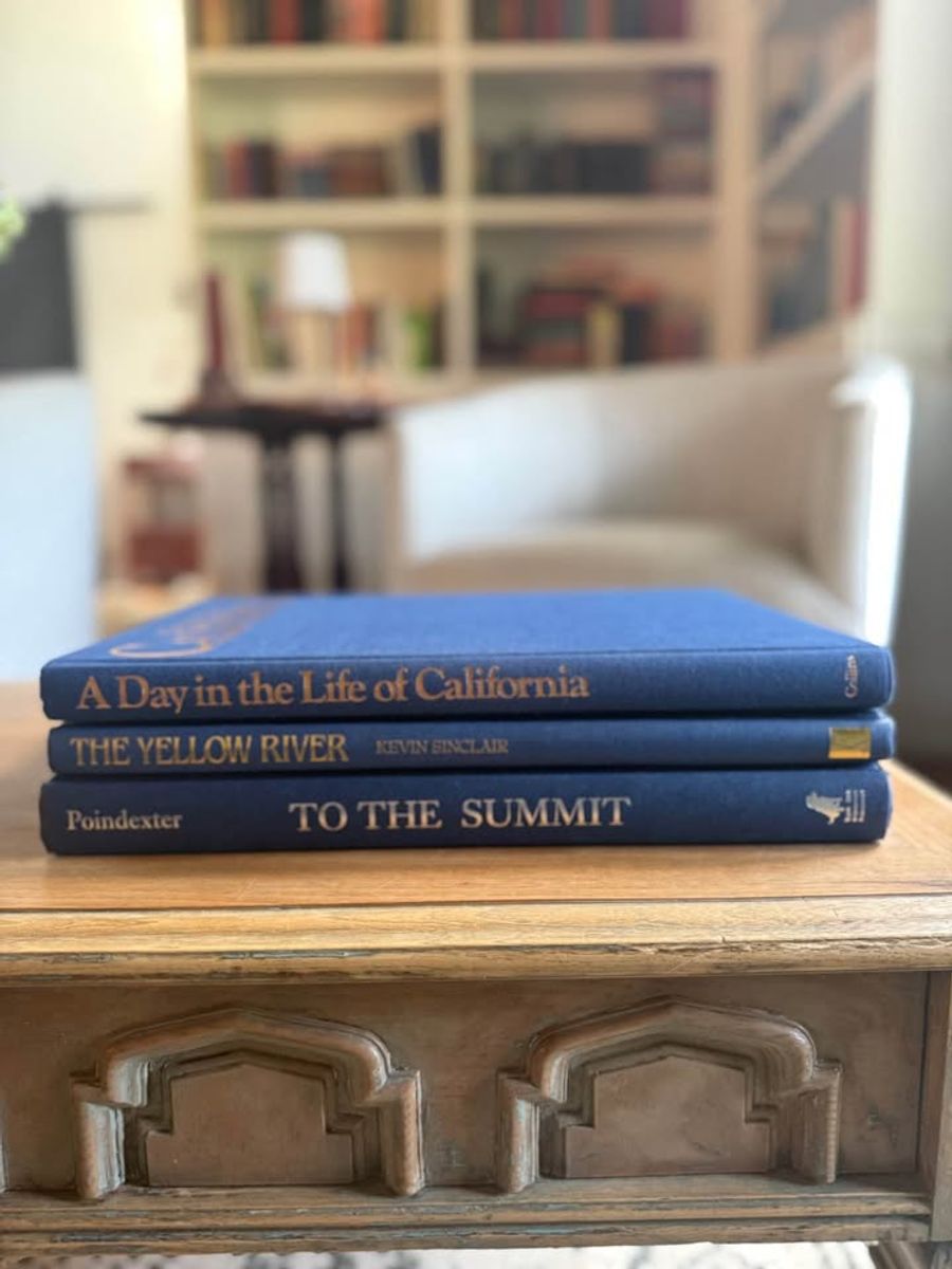 Blue, linen-like cloth covers, matte woven texture, subtle gold and metallic lettering, understated traditional styling