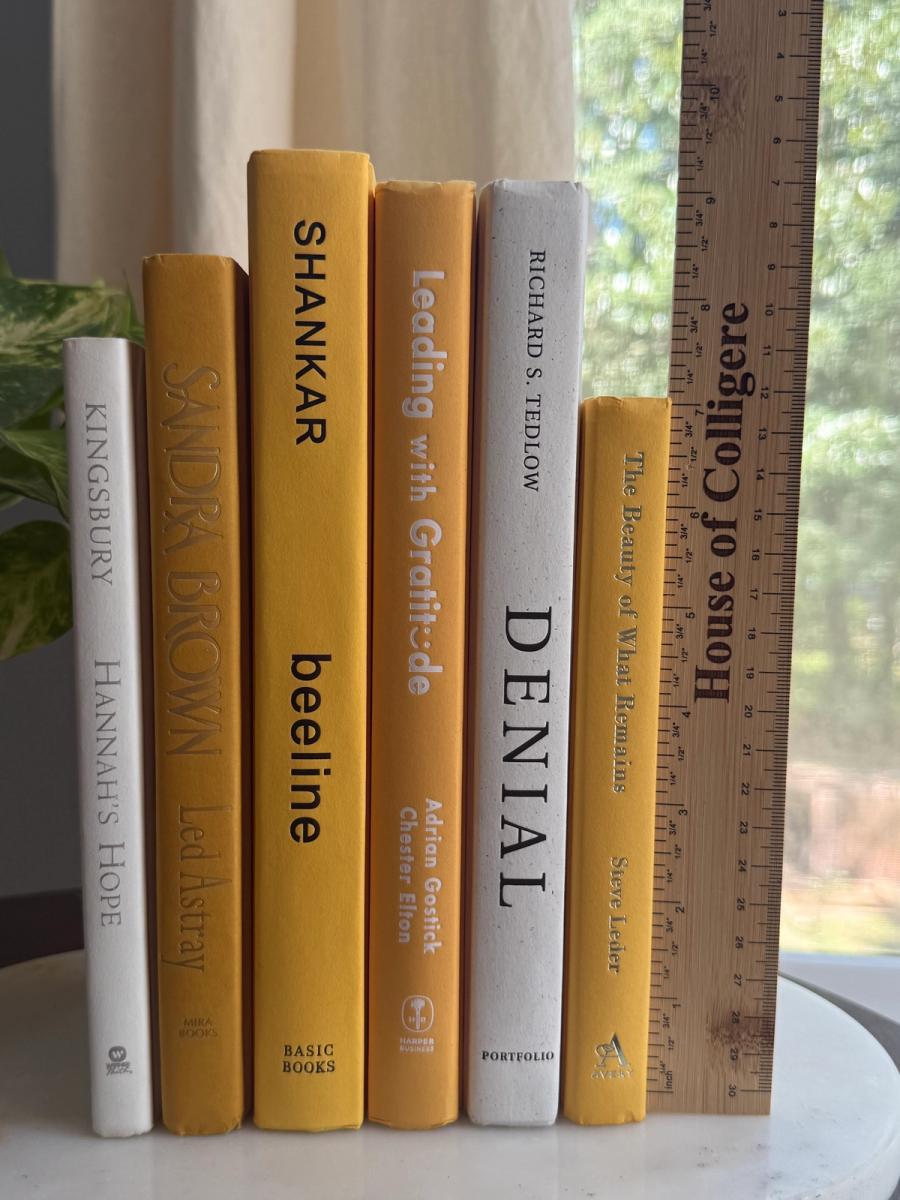 Six curated hardcover books in mustard yellow, golden ochre, cream, and soft white tones, tied with natural linen ribbon and displayed with a House of Colligere Modernist Edit No. 5 card.