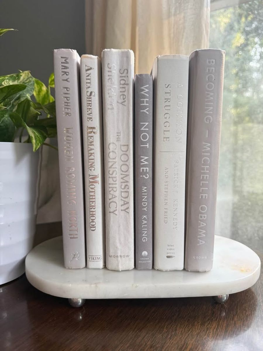 Curated collection of soft white, pale gray, warm greige, and stone-toned books with subtle tonal variation.