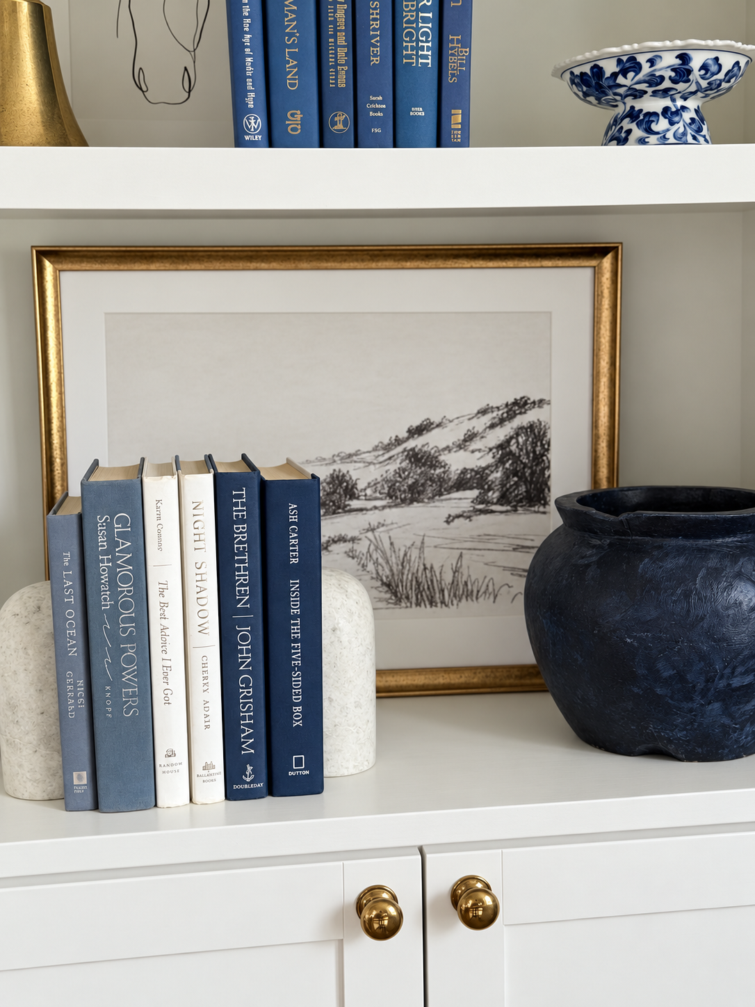 Curated collection of layered blue books ranging from pale coastal blue to deeper ocean tones.
