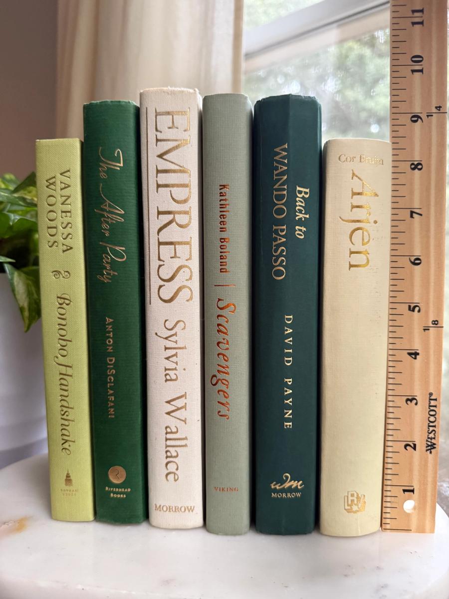 Curated collection of soft sage, olive, cream, and muted green books with botanical tones.