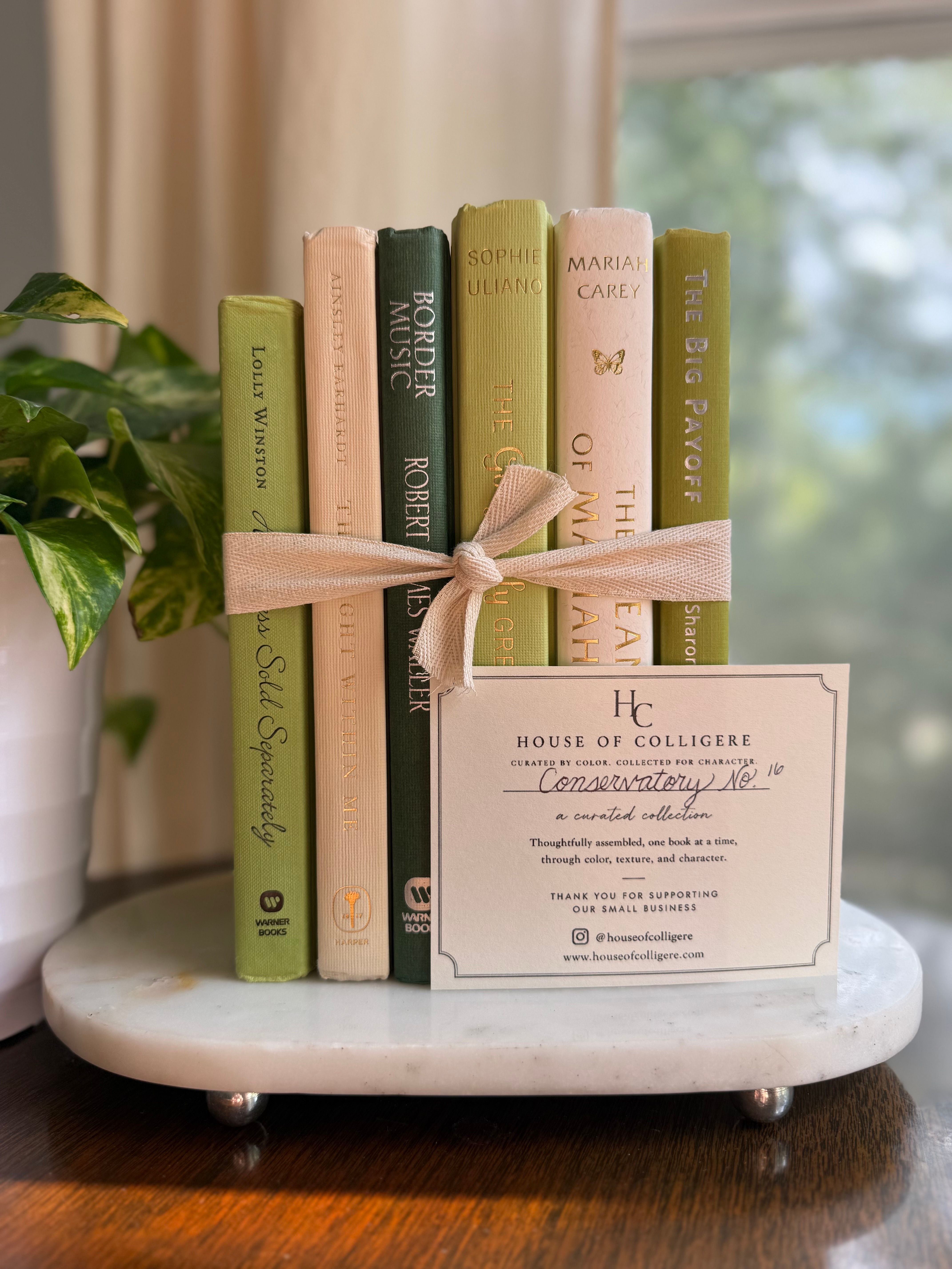 Curated collection of soft sage, olive, cream, and muted green books with botanical tones.