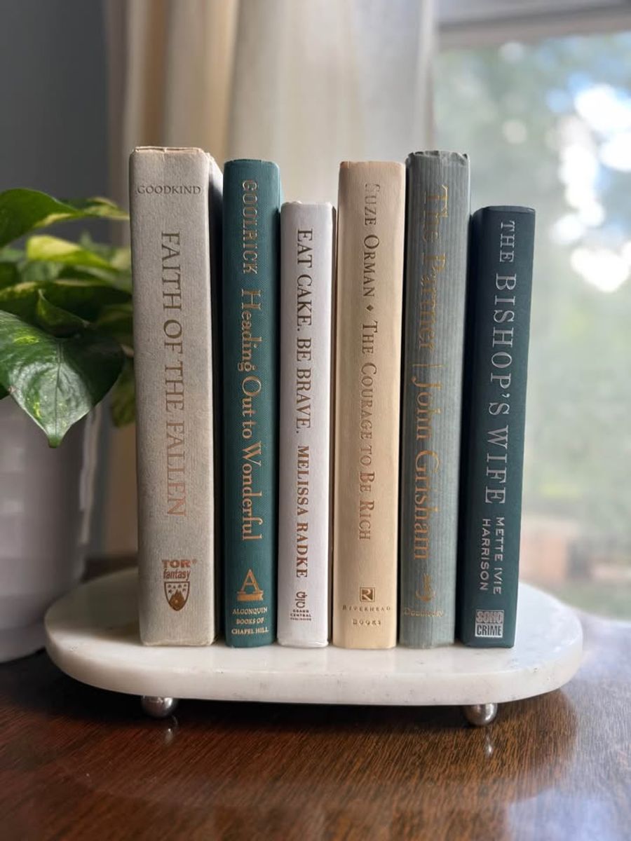 Curated collection of white, pale blue, sand, and soft coastal-neutral books with an airy, sun-faded look.