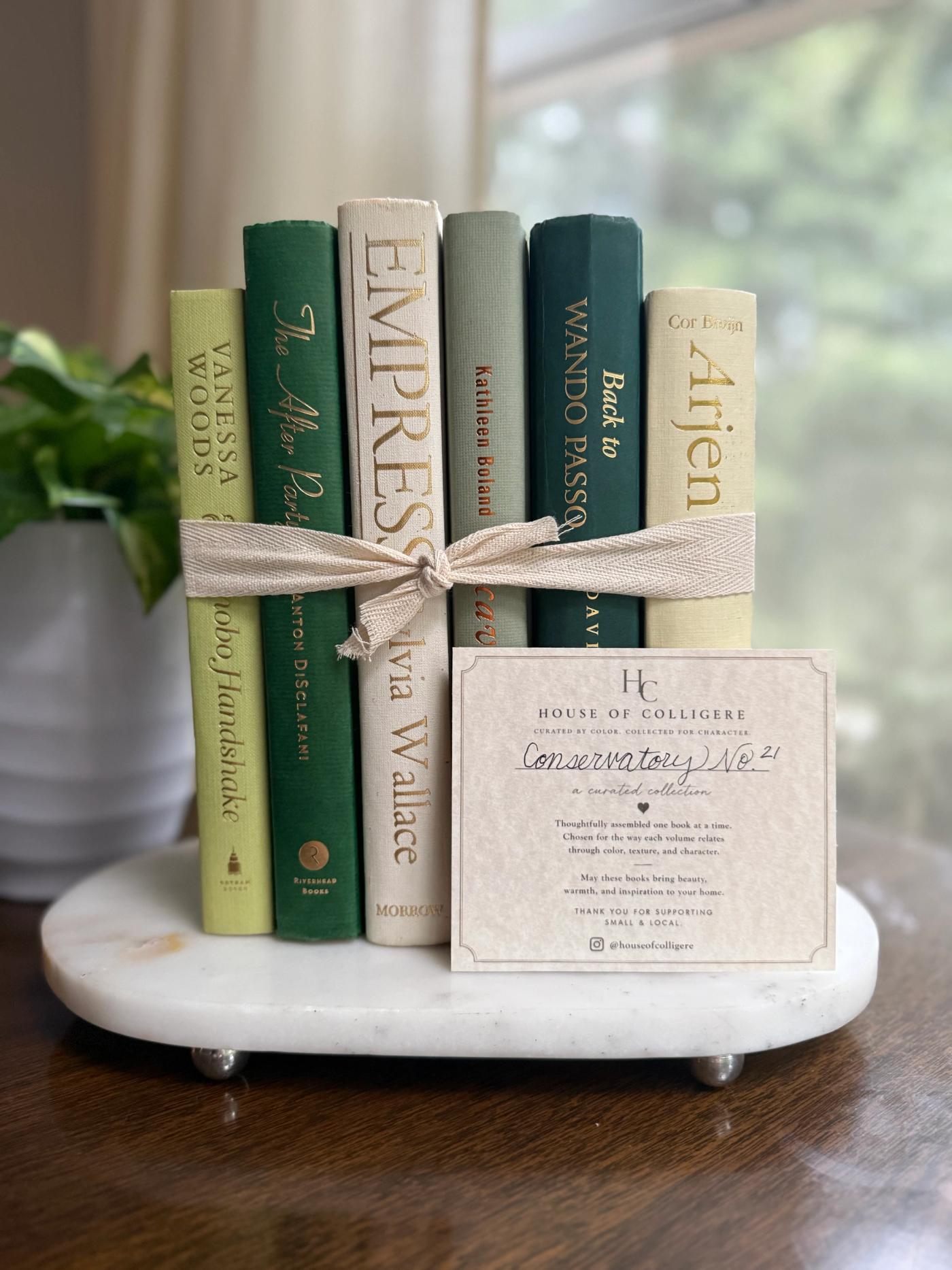 Curated collection of soft sage, olive, cream, and muted green books with botanical tones.