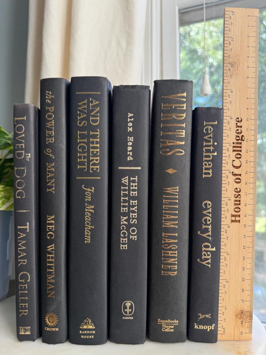 Curated collection of rich charcoal and black books with warm gold lettering and dramatic tonal depth.