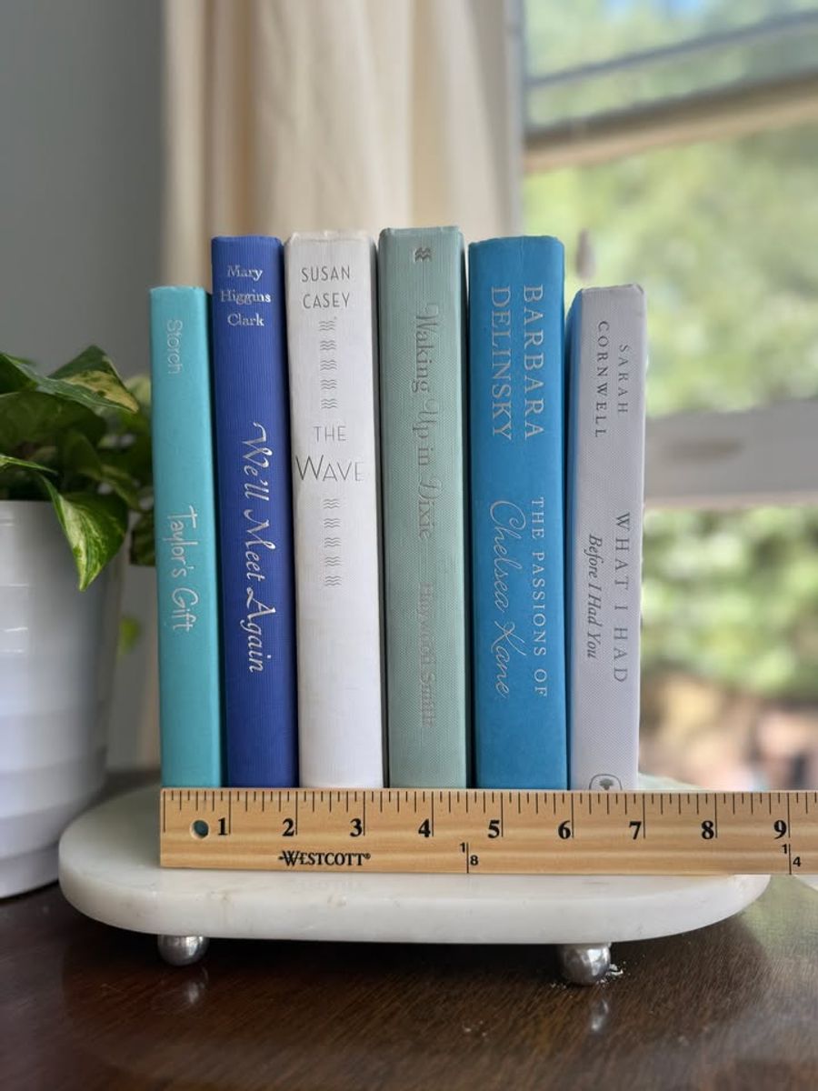 Sea Glass No. 33 decorative book collection in turquoise, cobalt blue, white, pale aqua, and soft gray tones, tied with neutral linen ribbon and styled on a marble table.