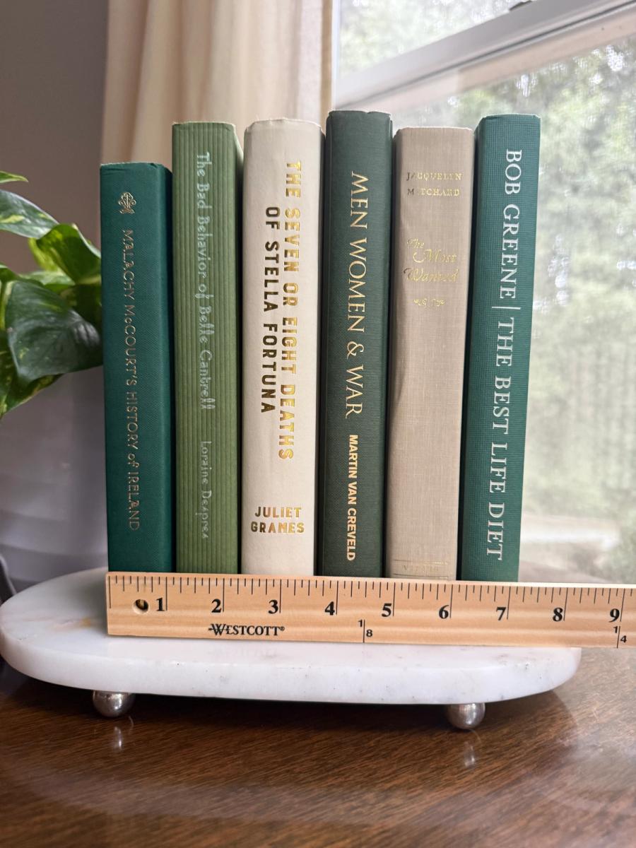 Curated collection of soft sage, olive, cream, and muted green books with botanical tones.