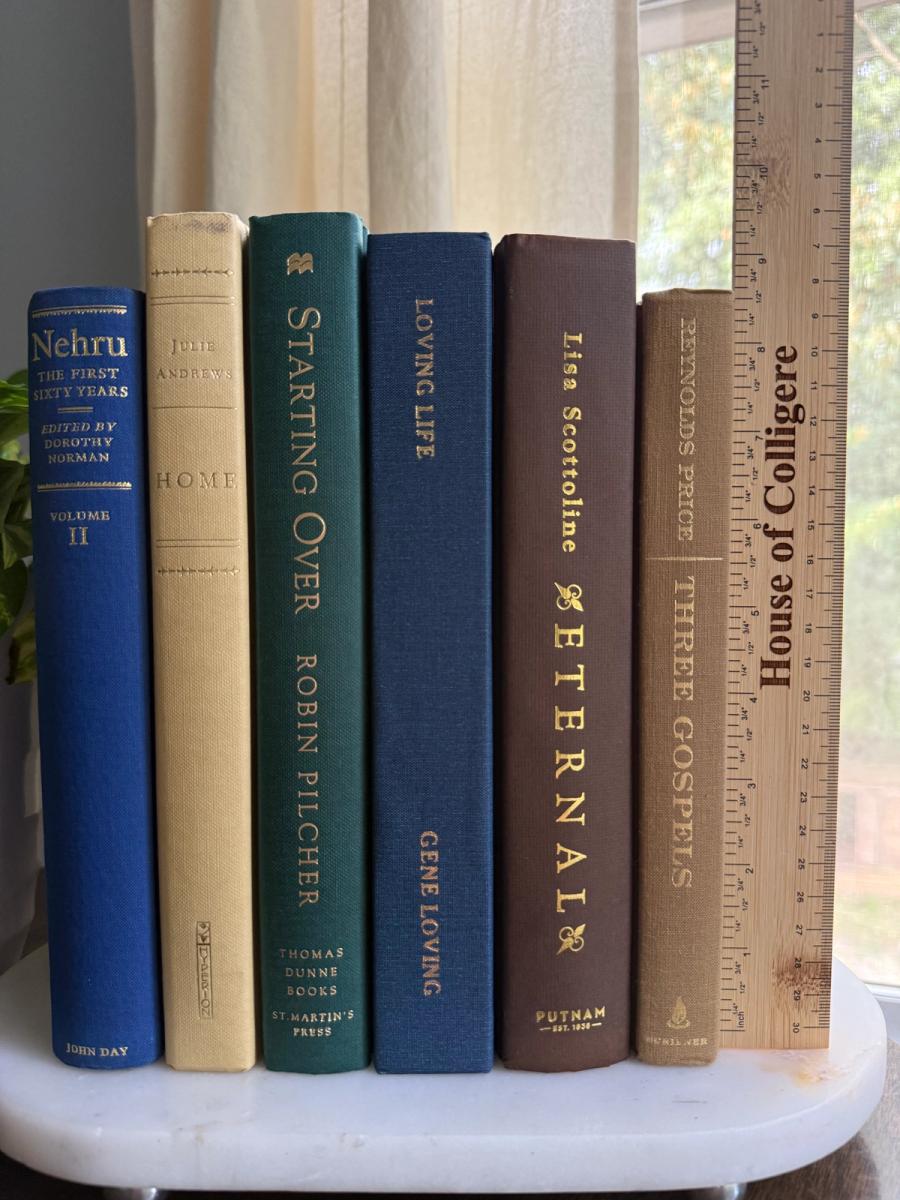 Curated collection of rich brown, hunter green, deep navy, and warm ivory books with classic gold accents.