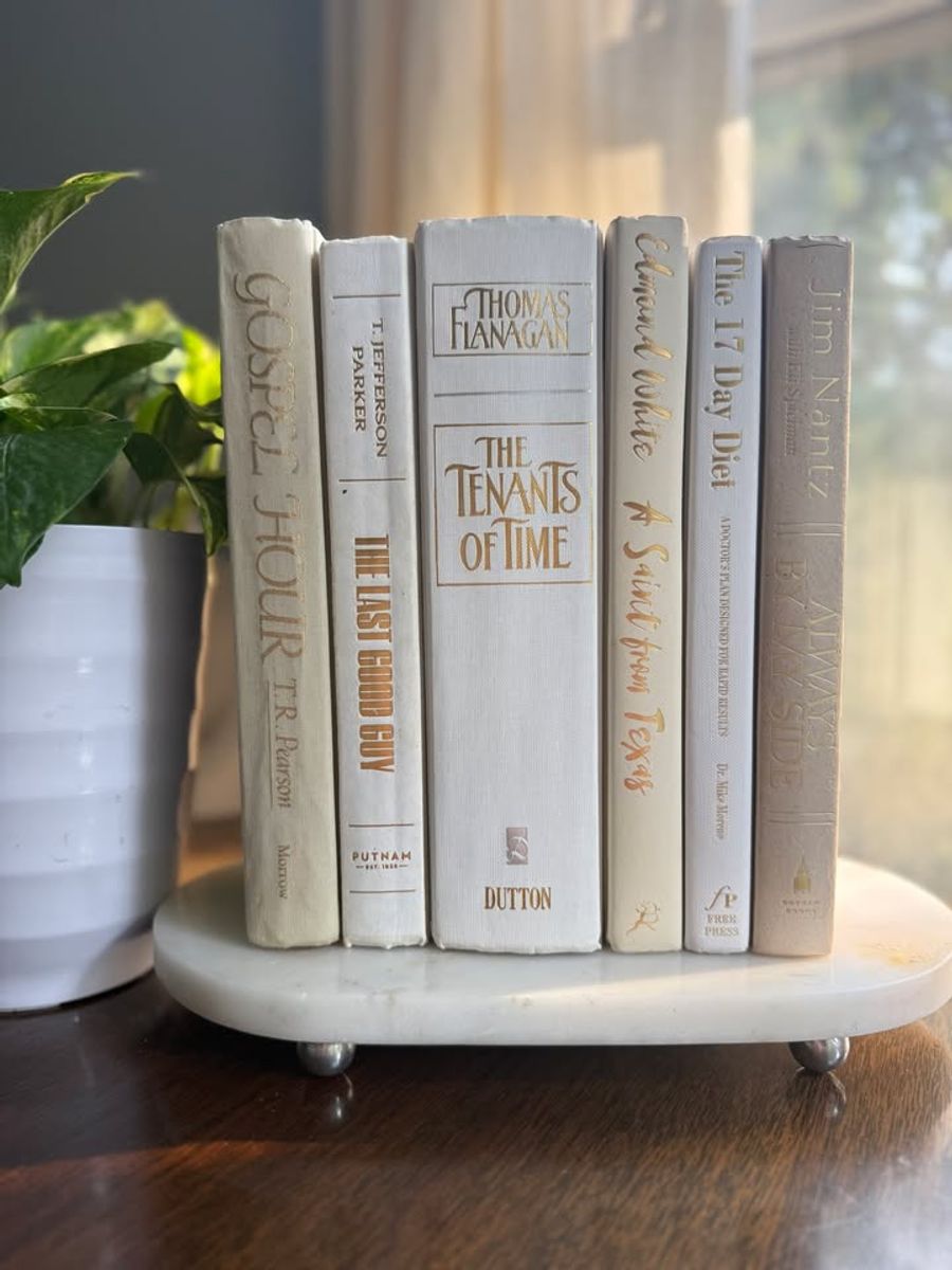 Curated collection of crisp white, ivory, and warm cream books with soft neutral tones.