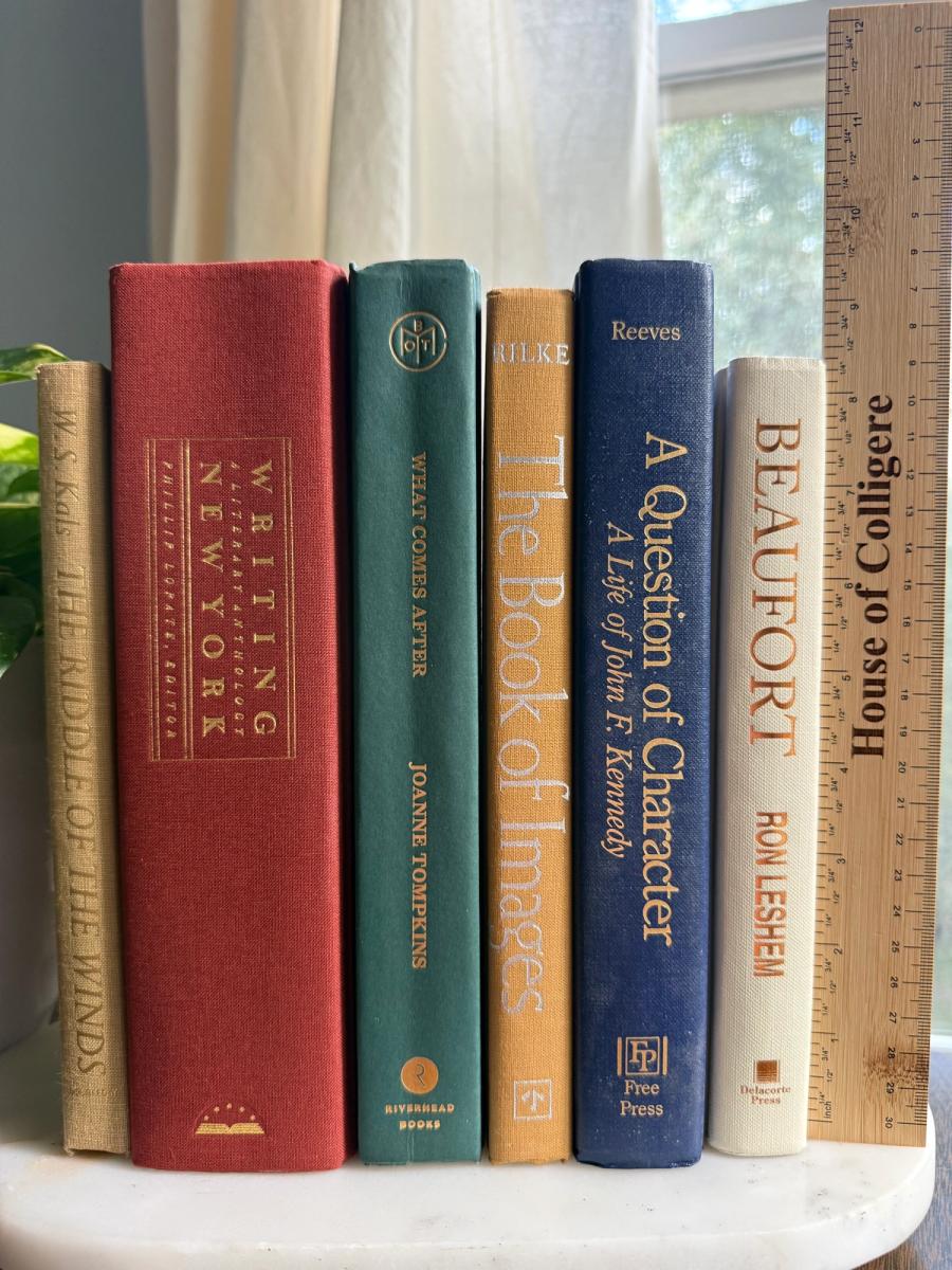 Curated collection of rich brown, hunter green, deep navy, and warm ivory books with classic gold accents.