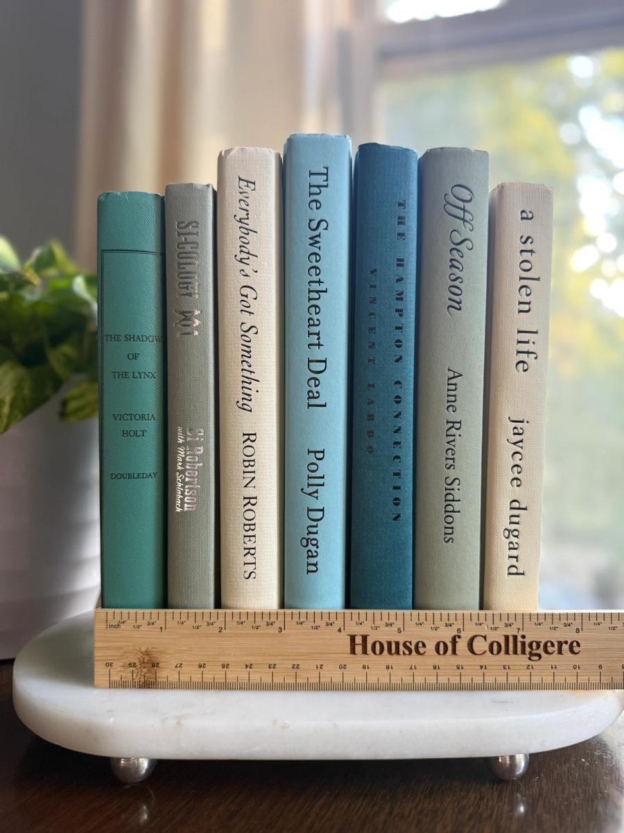 Curated collection of white, pale blue, sand, and soft coastal-neutral books with an airy, sun-faded look.