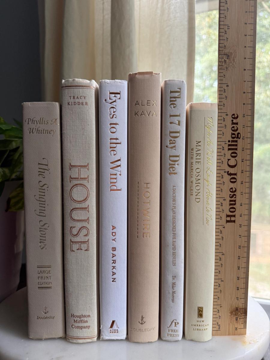 Six white, ivory, and pale taupe hardcover books tied with natural ribbon on a marble tray, with gold-toned lettering and a Linen No. 10 card.