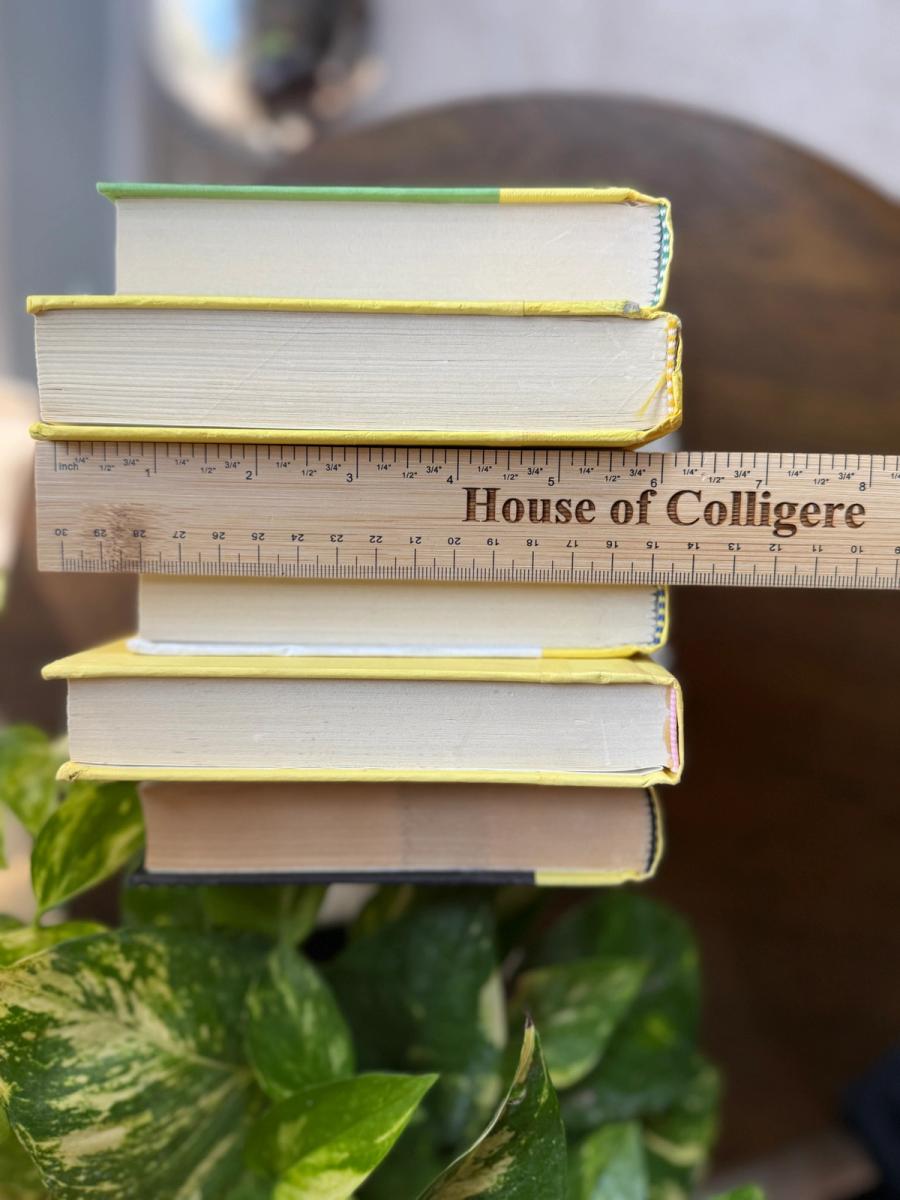 Curated collection of six mustard and golden yellow hardcover books tied with natural cotton ribbon, styled on a marble tray with a House of Colligere Modernist Edit No. 4 collection card.