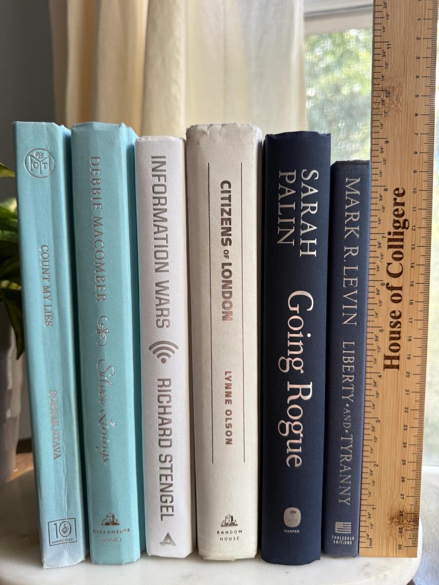 Curated collection of layered blue books ranging from pale coastal blue to deeper ocean tones.
