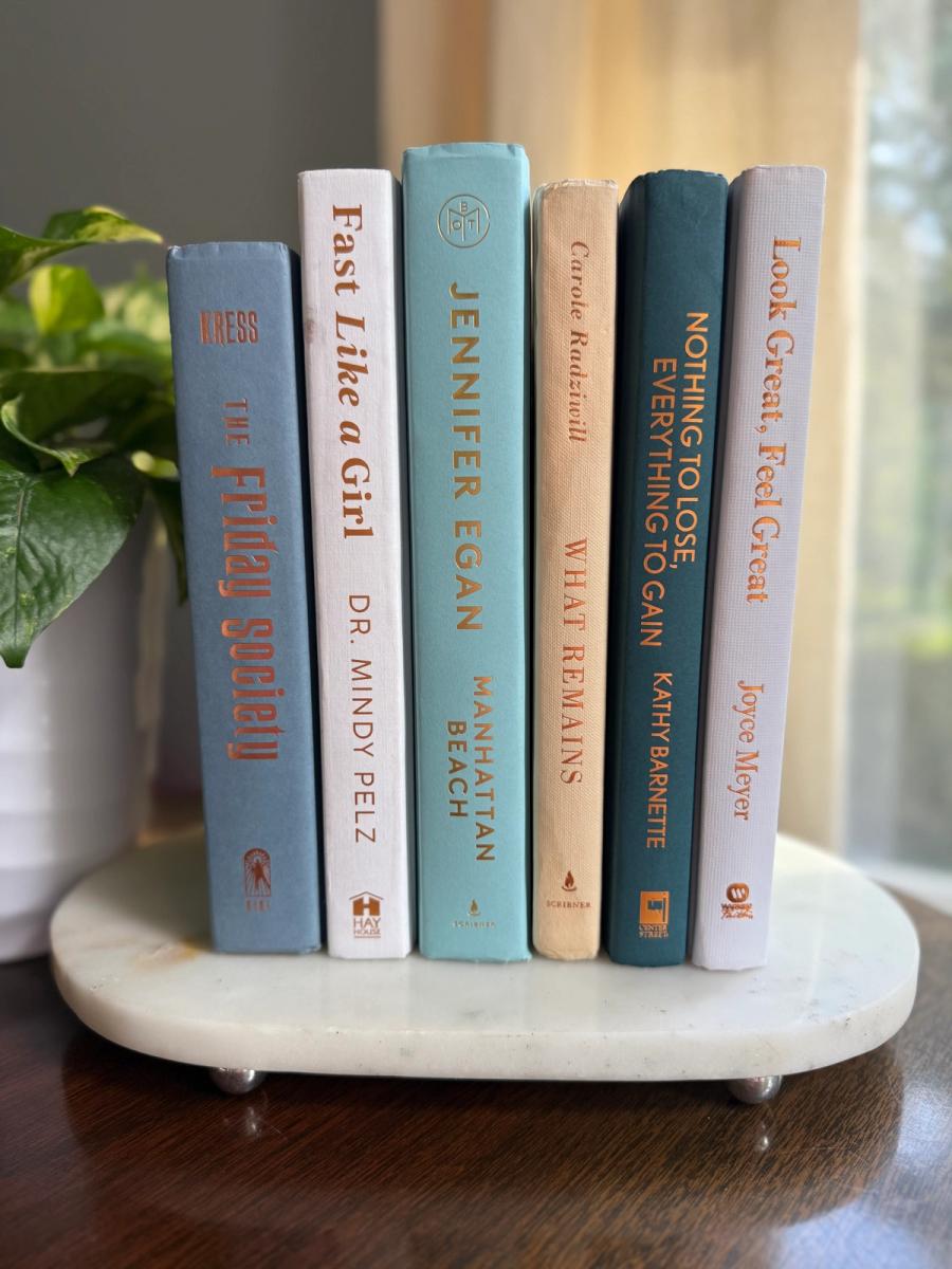 Curated collection of white, pale blue, sand, and soft coastal-neutral books with an airy, sun-faded look.