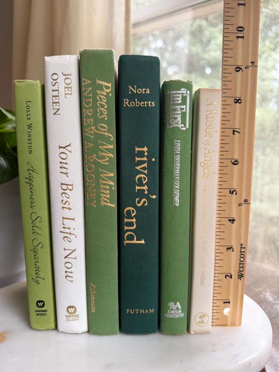 Curated collection of soft sage, olive, cream, and muted green books with botanical tones.