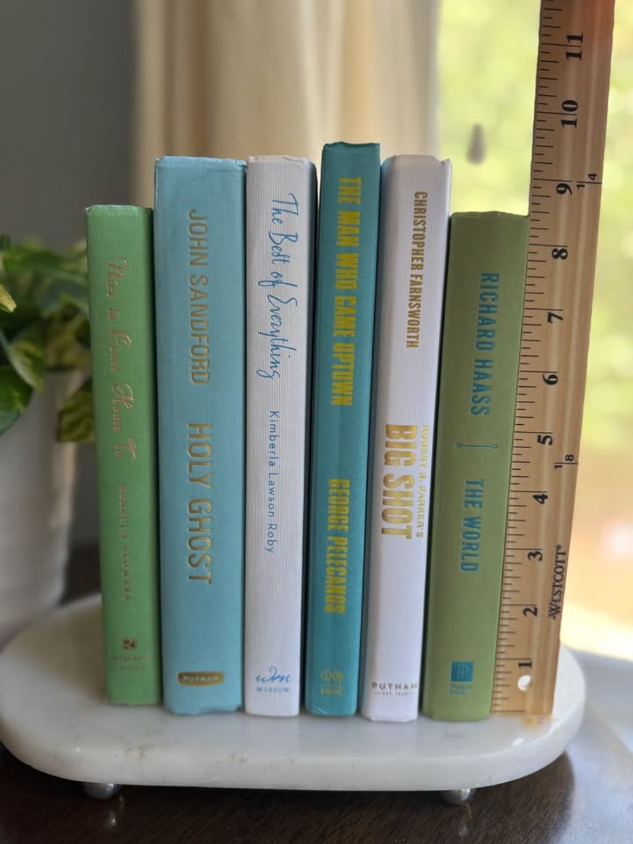 Modernist Edit No. 11 decorative book collection in fresh green, aqua, teal, ivory, and olive tones, tied with neutral linen ribbon and styled on a marble table.