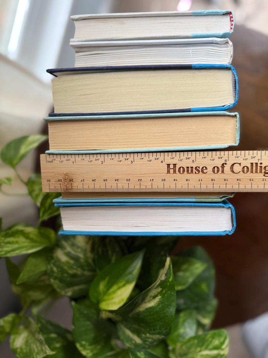 Curated collection of six hardcover books in cobalt blue, sage green, pale aqua, and soft white, tied with natural cotton ribbon and styled beside a House of Colligere collection card.