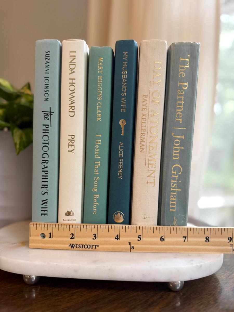 Curated collection of white, pale blue, sand, and soft coastal-neutral books with an airy, sun-faded look.