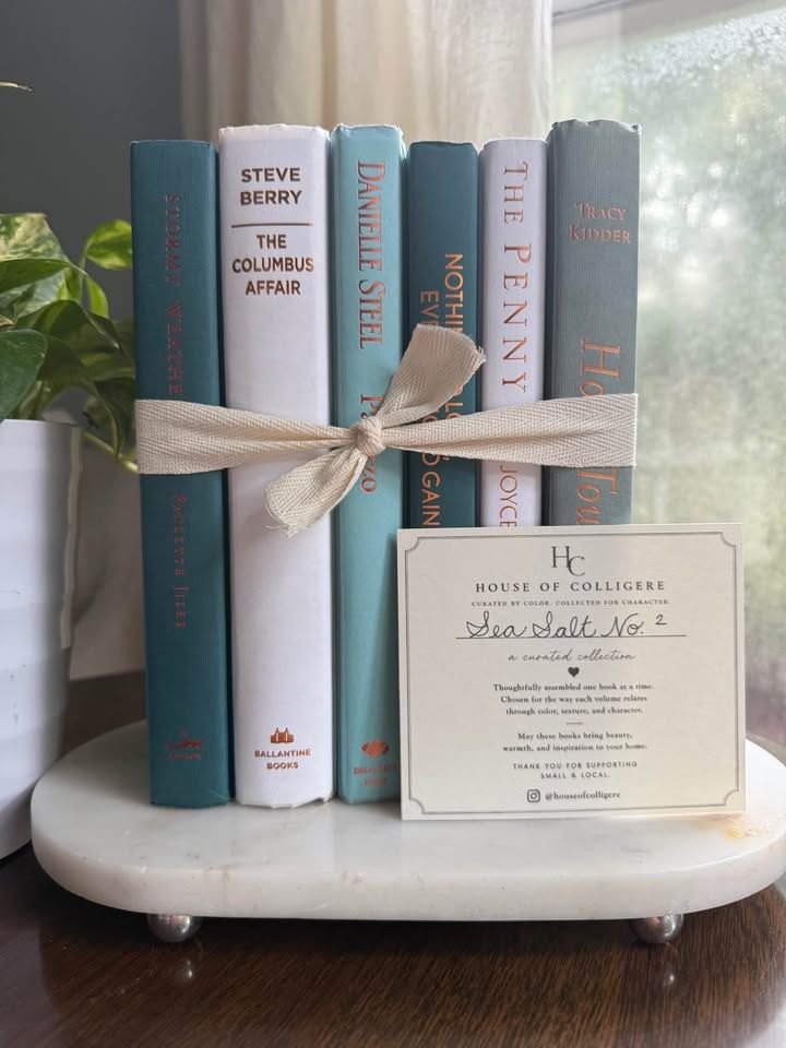 Curated collection of white, pale blue, sand, and soft coastal-neutral books with an airy, sun-faded look.