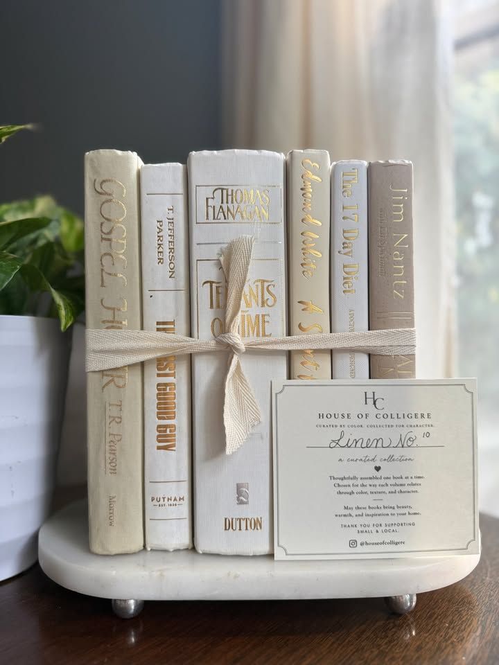 Curated collection of crisp white, ivory, and warm cream books with soft neutral tones.